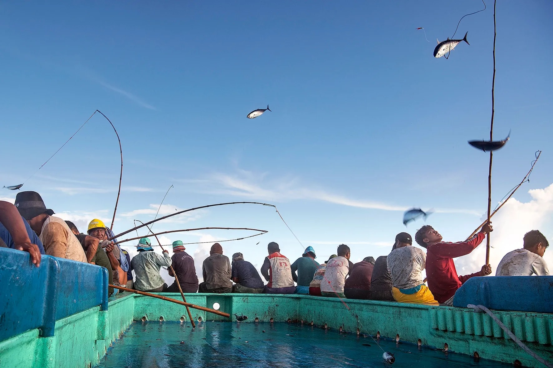 Vissers in Bitung vangen tonijn met hengel en lijn op de boot.